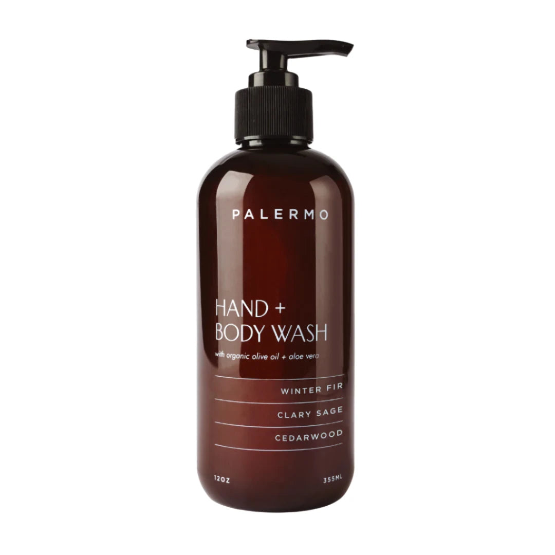 A dark brown bottle of Palermo Hand + Body Wash with a pump dispenser, labeled 'Winter Fir' with 'Claytonia sage' and 'Cedarwood' mentioned as scents.